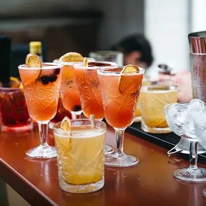 Cocktails latins colorés garnis de tranches d’orange sur comptoir élégant